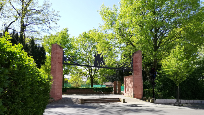 Eingang des Stadtgartens mit Blick auf den aus rotem Sandstein errichtete Mahnmal